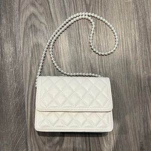 White purse with pearl handle.
